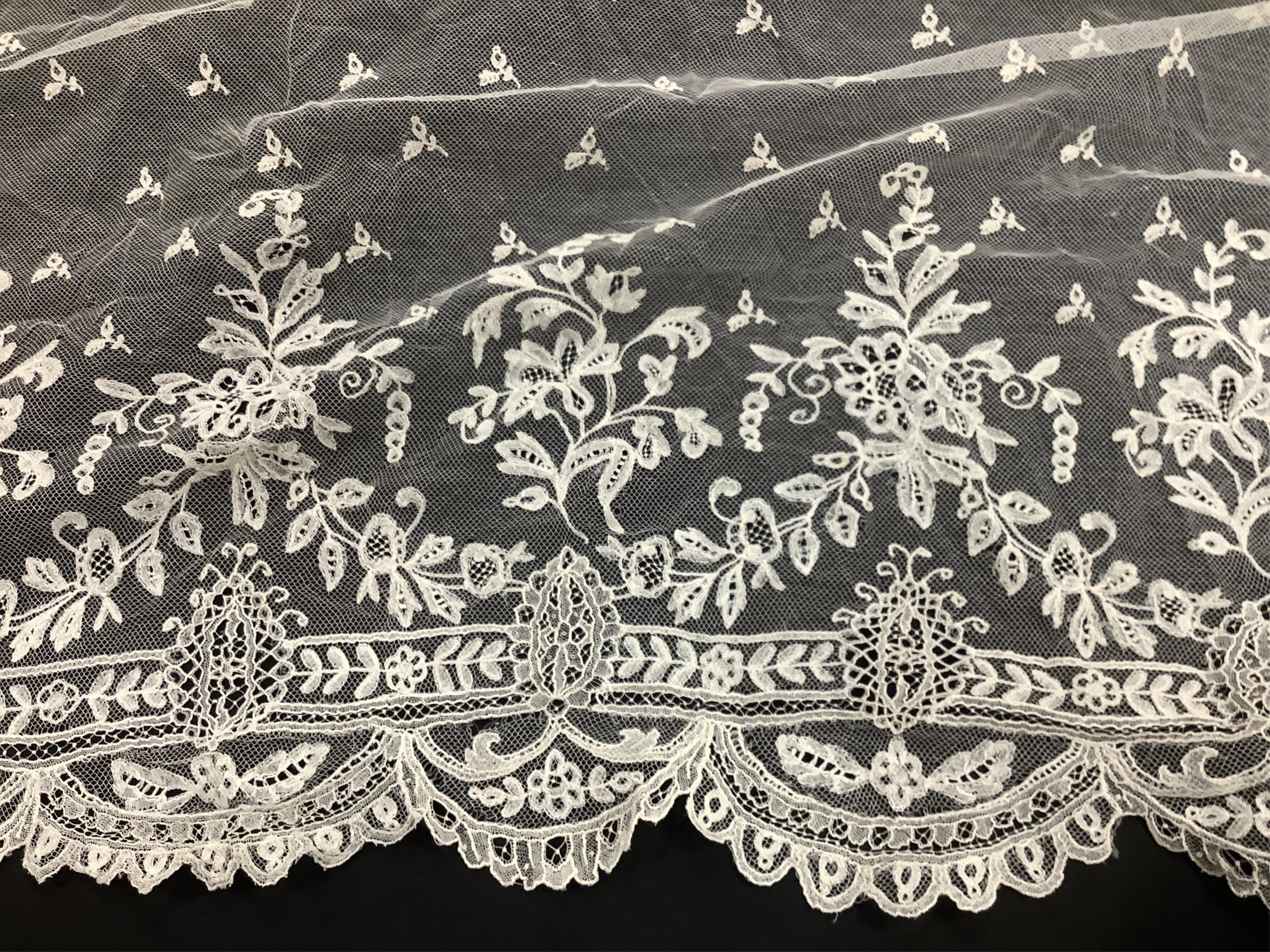 A small late 19th century Brussels wedding veil, an earlier Brussels bobbin bonnet veil, two needle run bonnet veils, various lace sleeves and a lilac silk and lace coverlet., Brussels veil 140cm x 132cm. Condition - the